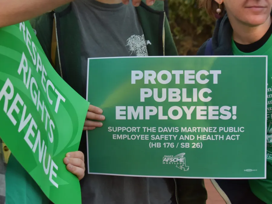 PROTECT PUBLIC EMPLOYEES sign held